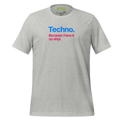 A Heather unisex t-shirt featuring minimalist typography on the chest. The text reads "Techno." in bold blue letters, followed by the subtext "Because i have it on vinyl." in pink. Designed for electronic music fans and vinyl collectors.